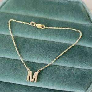 gold letter jewelry created by the jeweler ryan